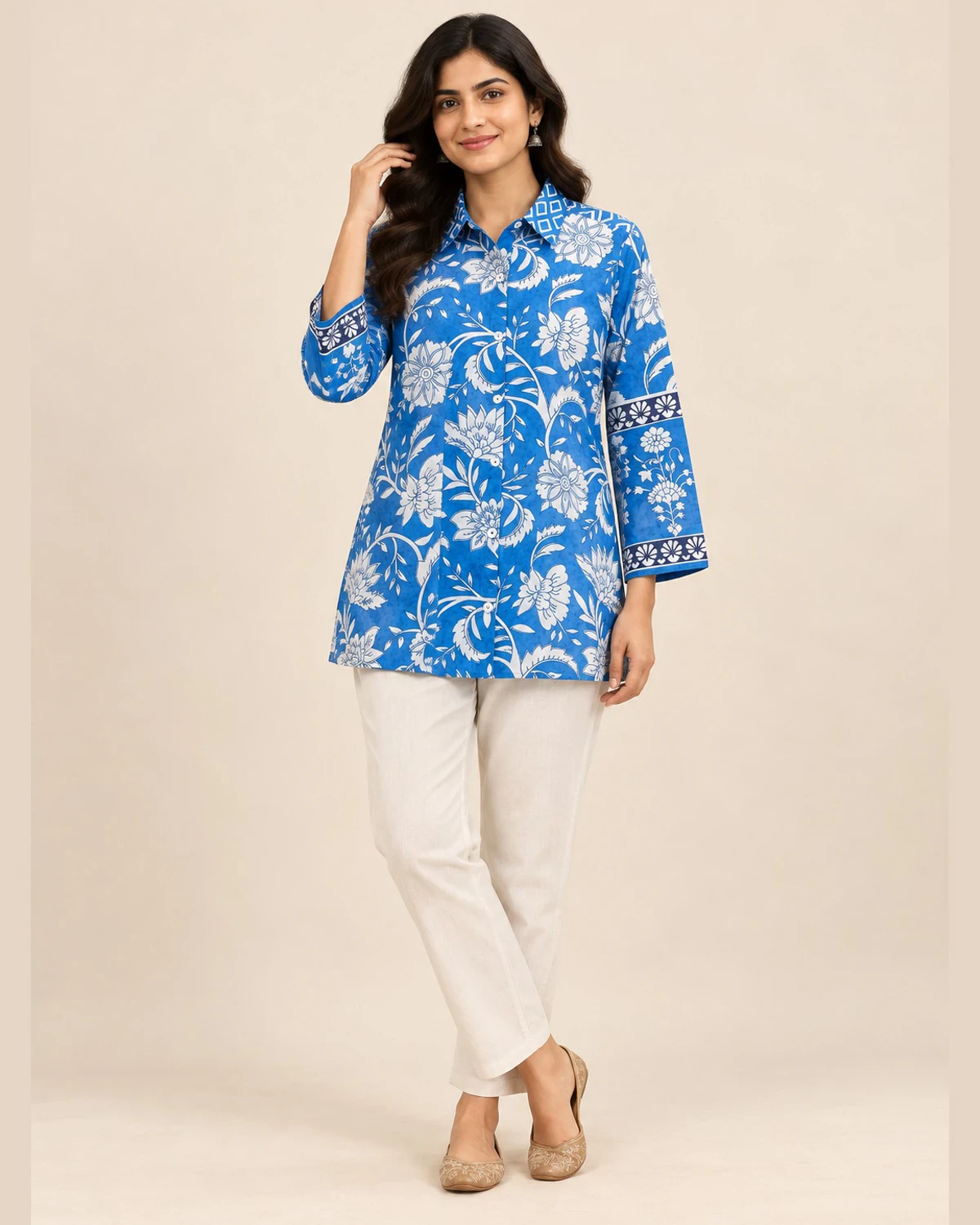 Woman wearing a blue and white floral print shirt kurti with cream trousers