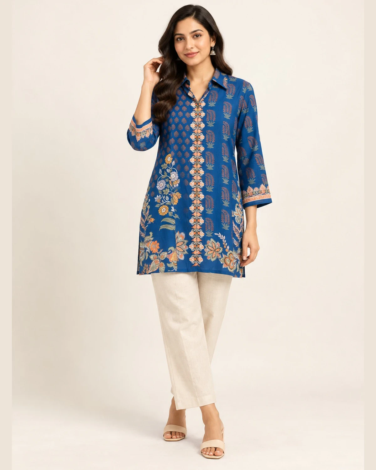 Woman wearing a royal blue floral print shirt kurti with cream trousers
