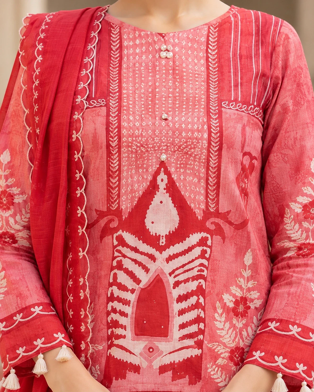 Close-up of the red kurta, showing an ivory motif print and tassel trims