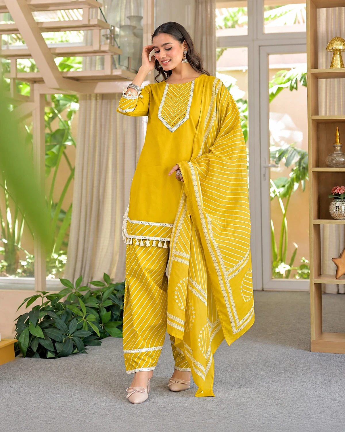 Woman wearing a yellow kurta, trousers and dupatta