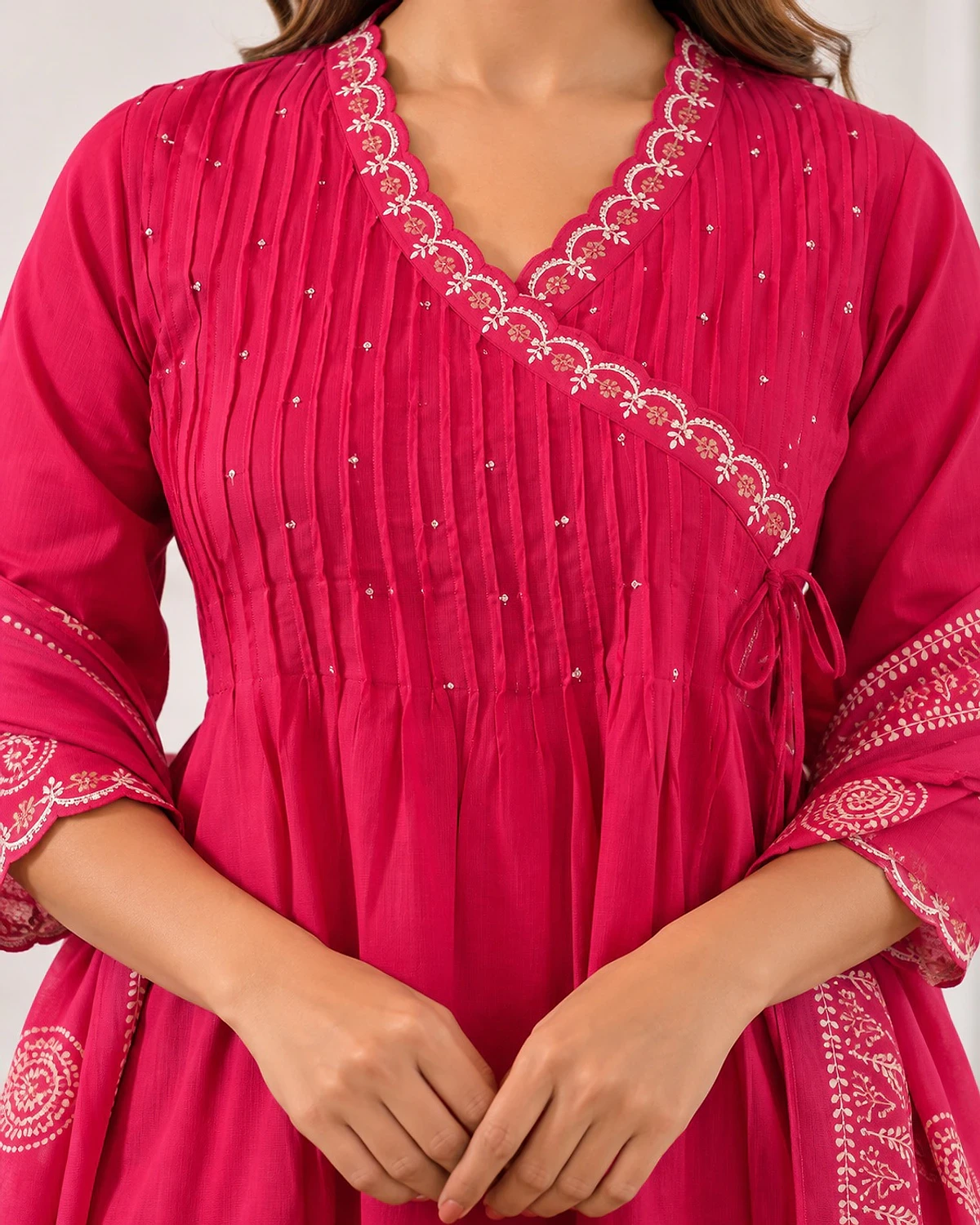 Close-up of the fuchsia kurta, showing an angrakha wrap neckline and pintucks