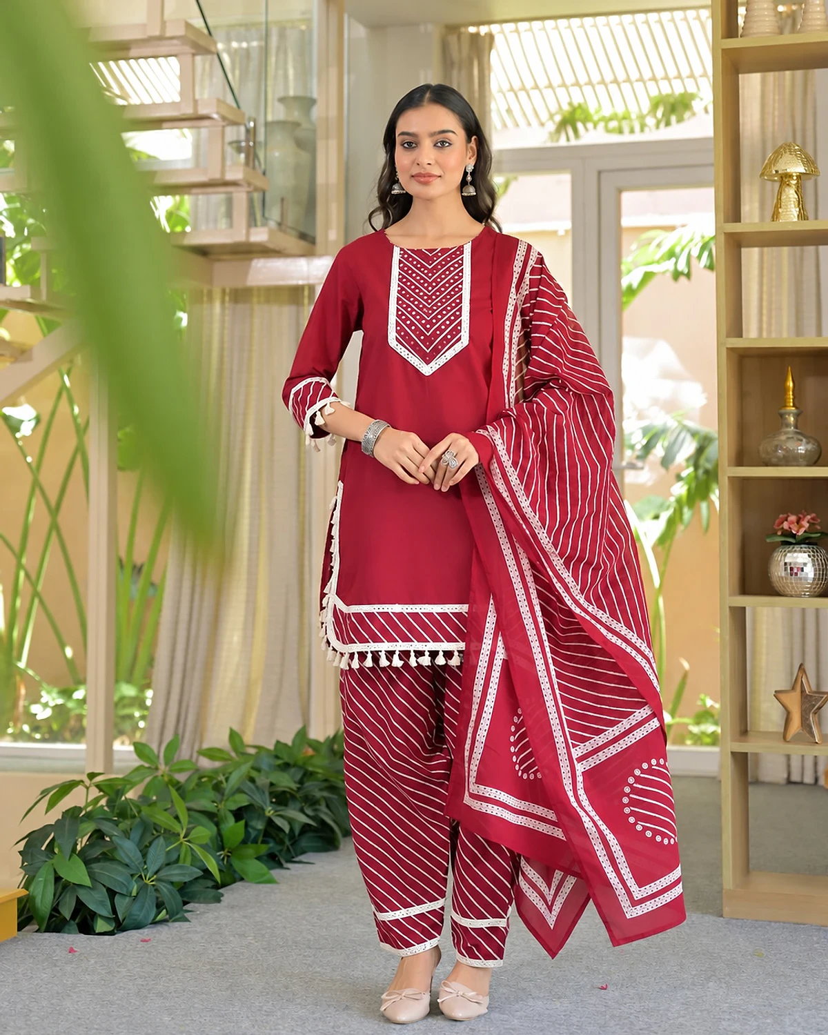 Woman wearing a maroon red kurta, trousers and dupatta