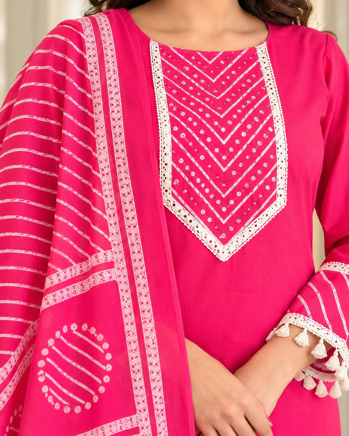 Close-up of the pink kurta, showing a lace yoke and tassel hem