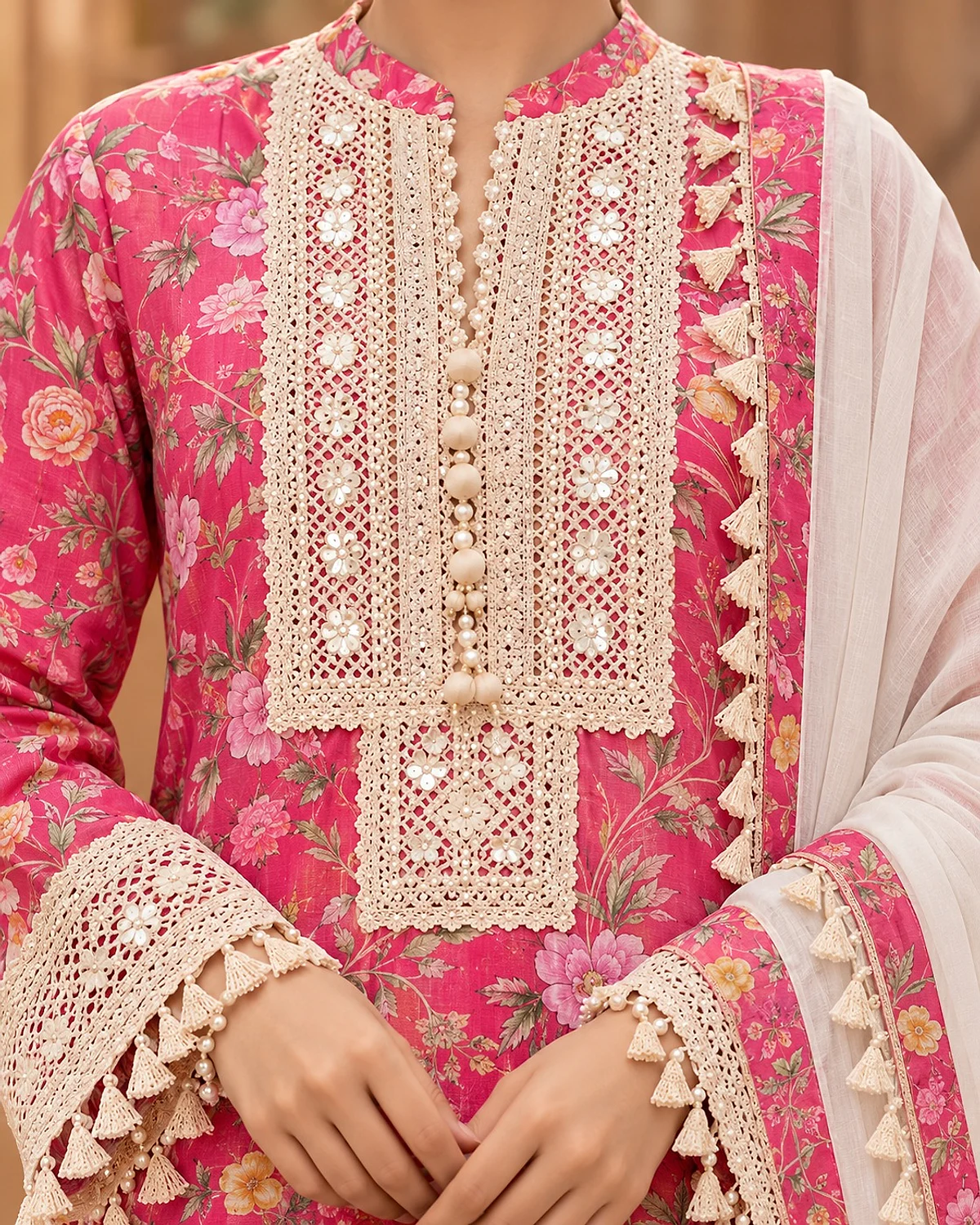 Close-up of the pink kurta, showing a crochet lace yoke and tassel trims