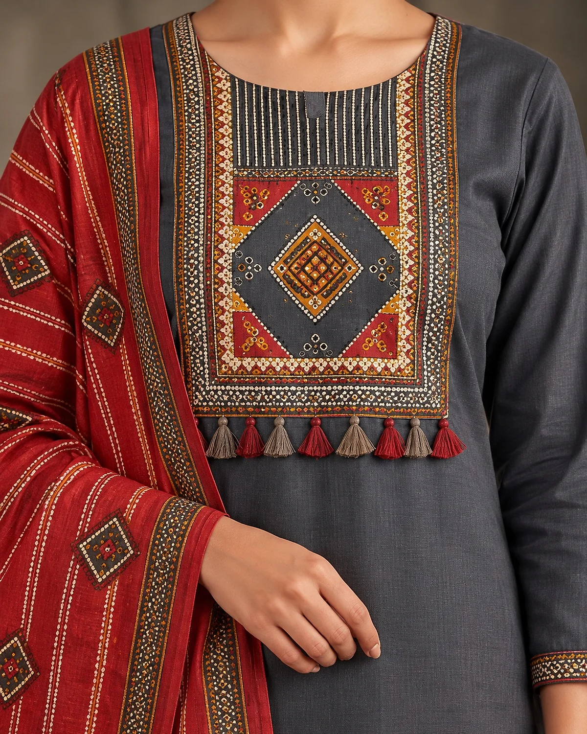 Close-up of the charcoal grey kurta, showing a geometric yoke with tassels