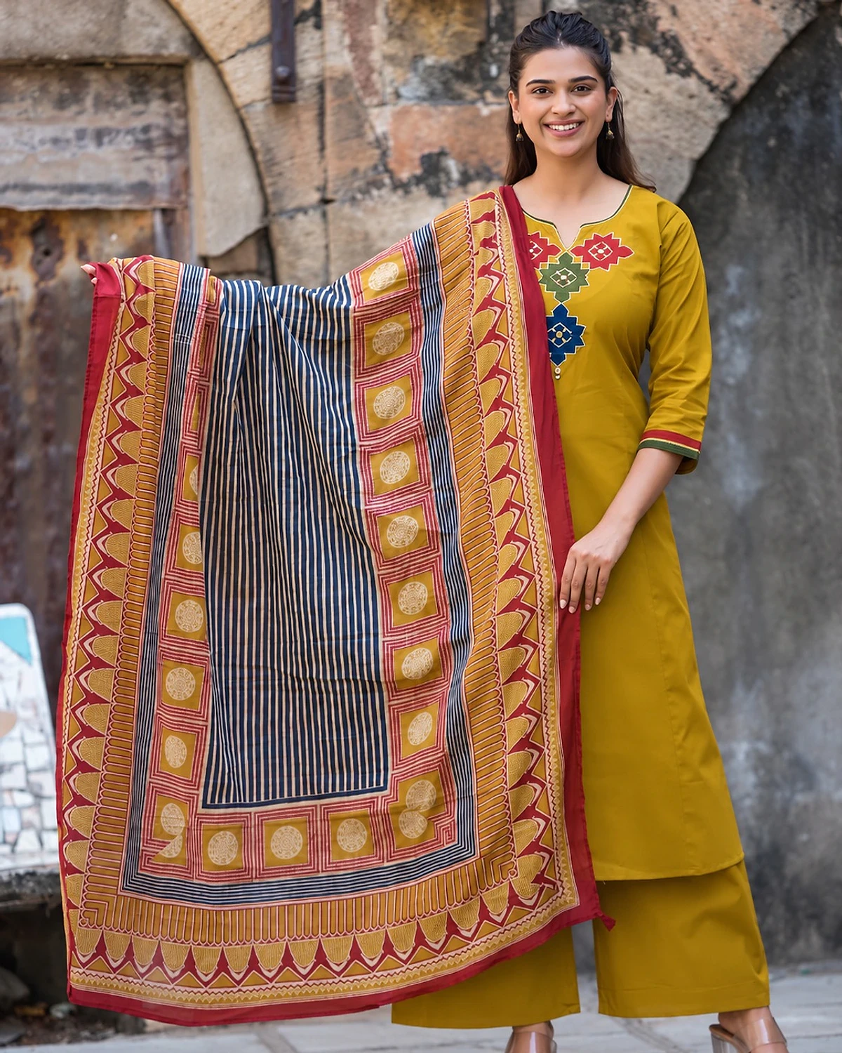 Woman wearing a mustard kurta, palazzo and dupatta