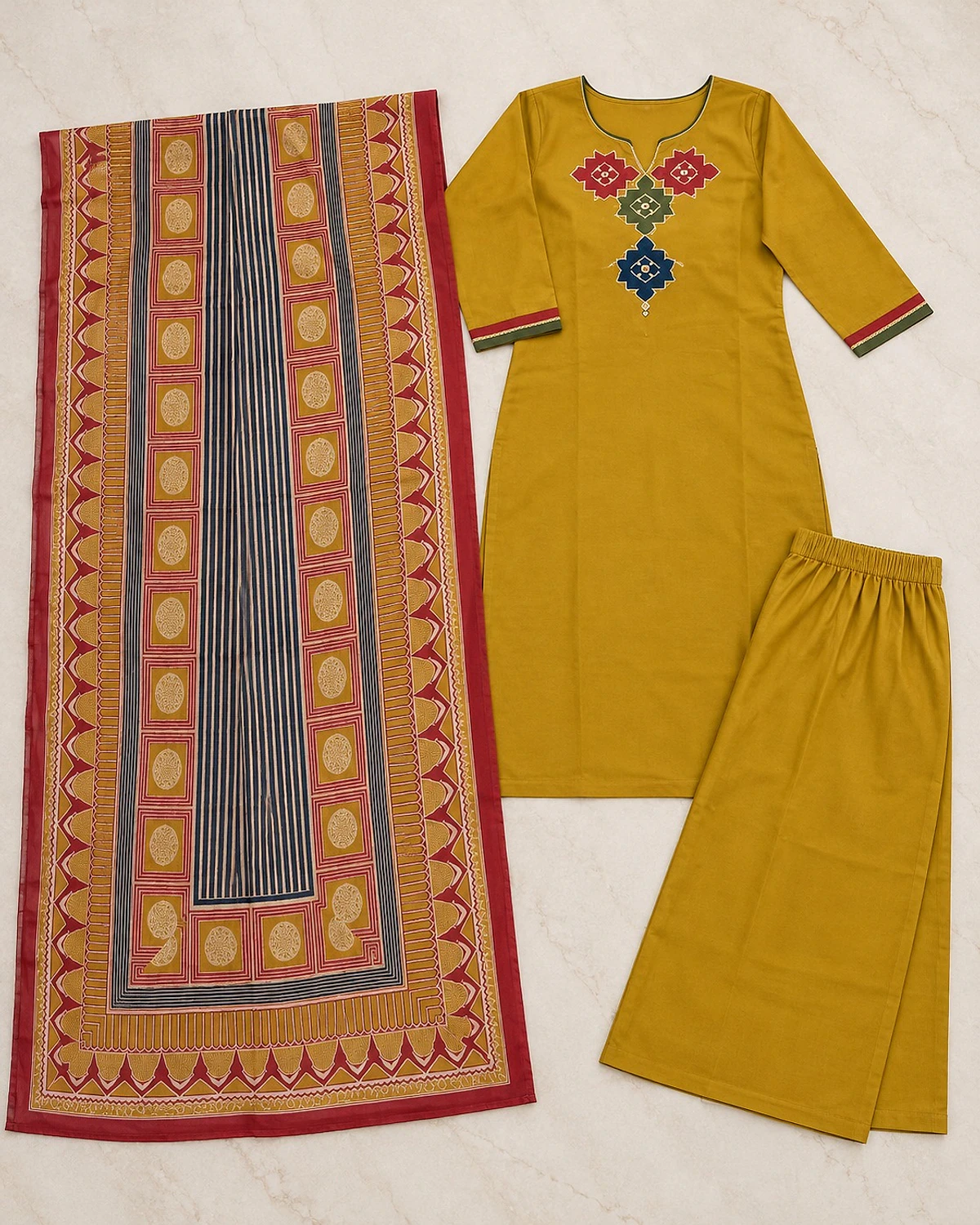 Mustard kurta, palazzo and dupatta laid out flat