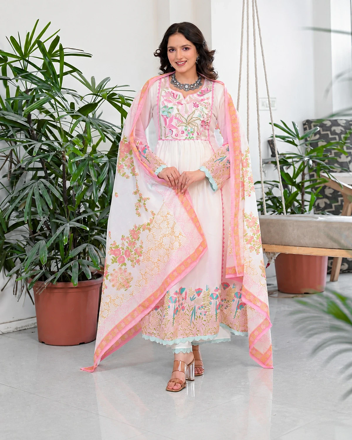 Woman wearing a white kurta, trousers and dupatta