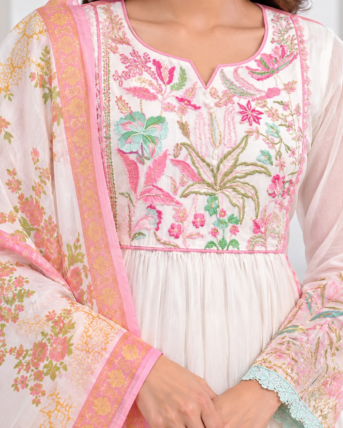 Close-up of the white kurta, showing a pastel floral yoke and hem