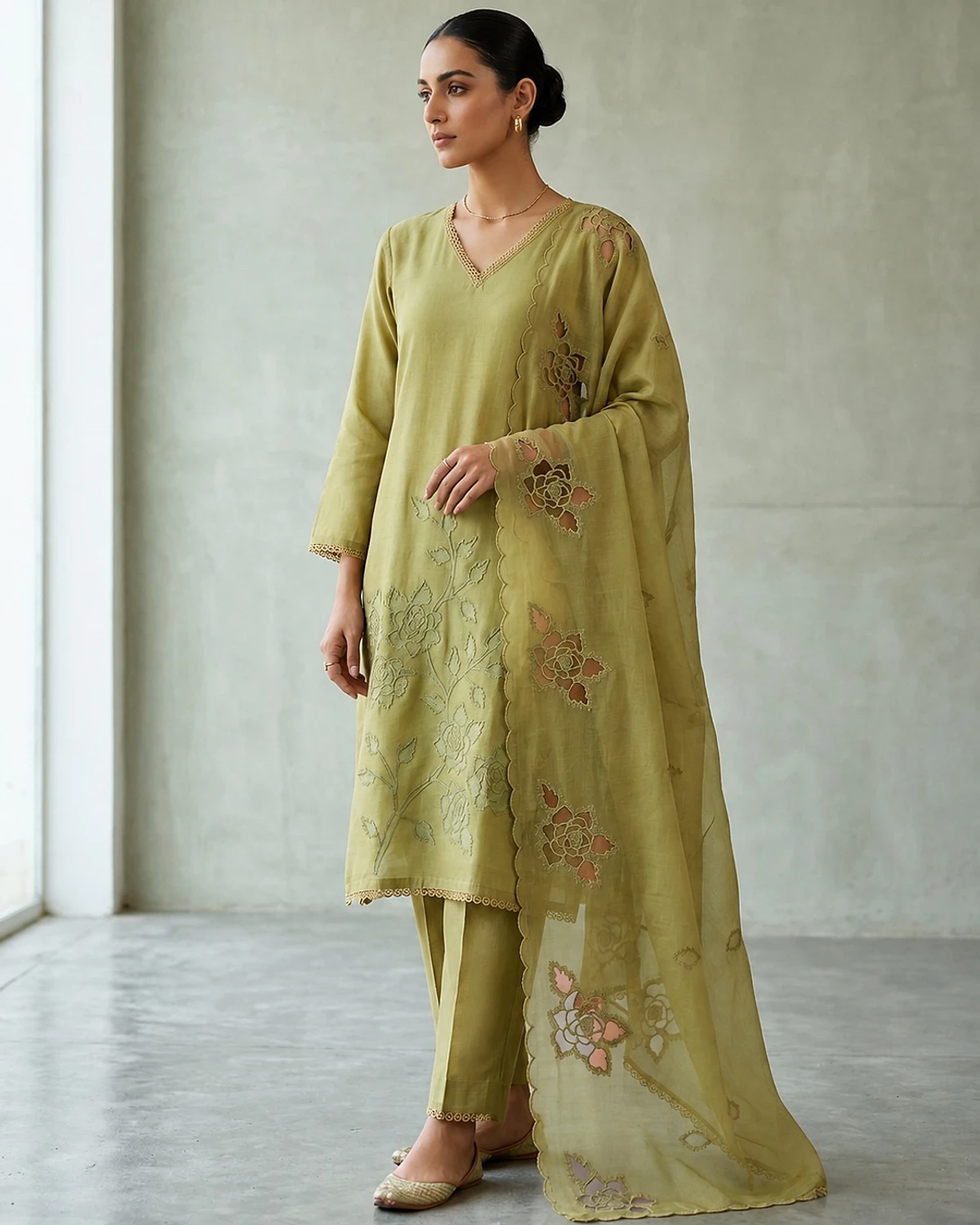 Woman wearing a olive green kurta, trousers and dupatta
