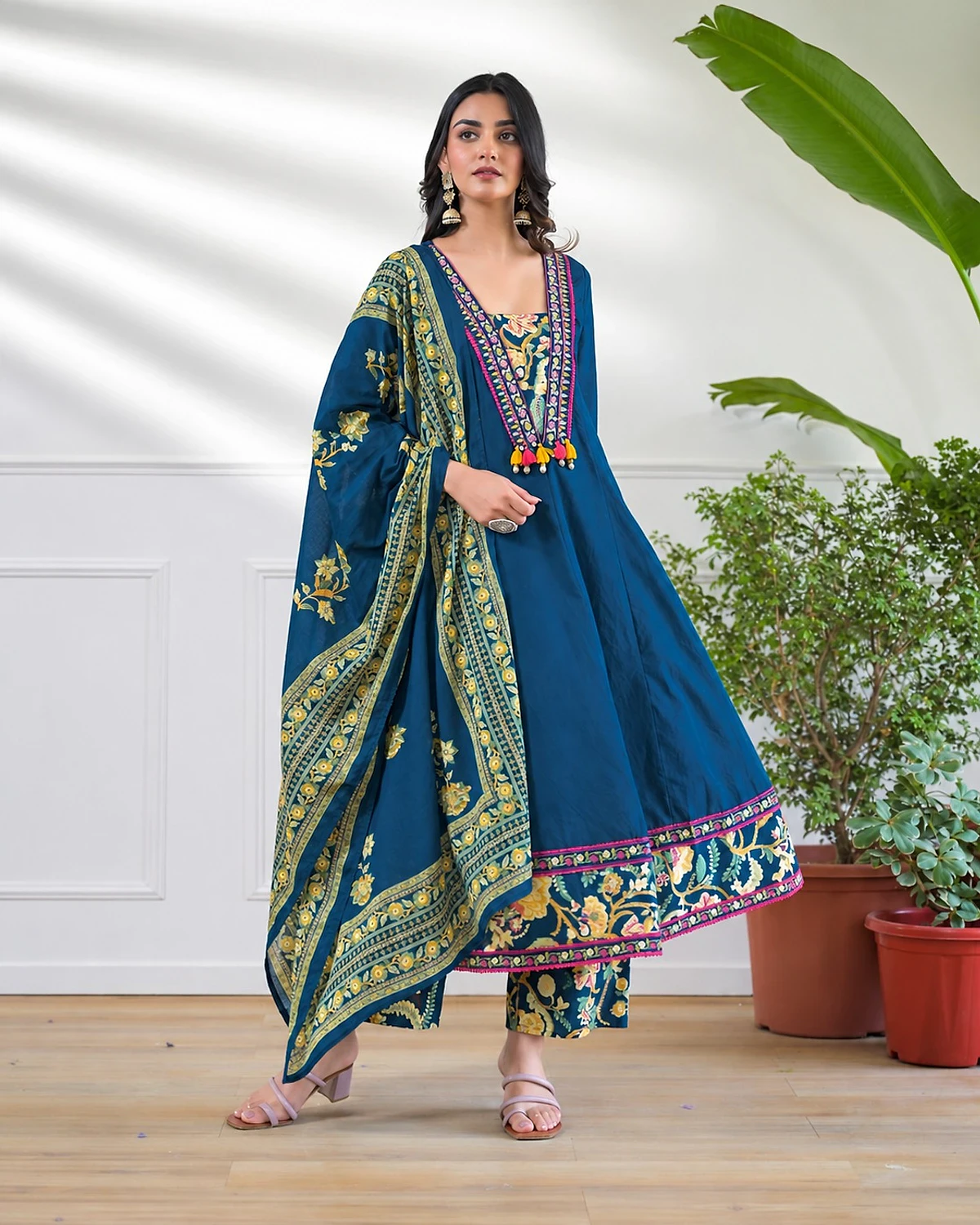 Woman wearing a teal blue kurta, trousers and dupatta