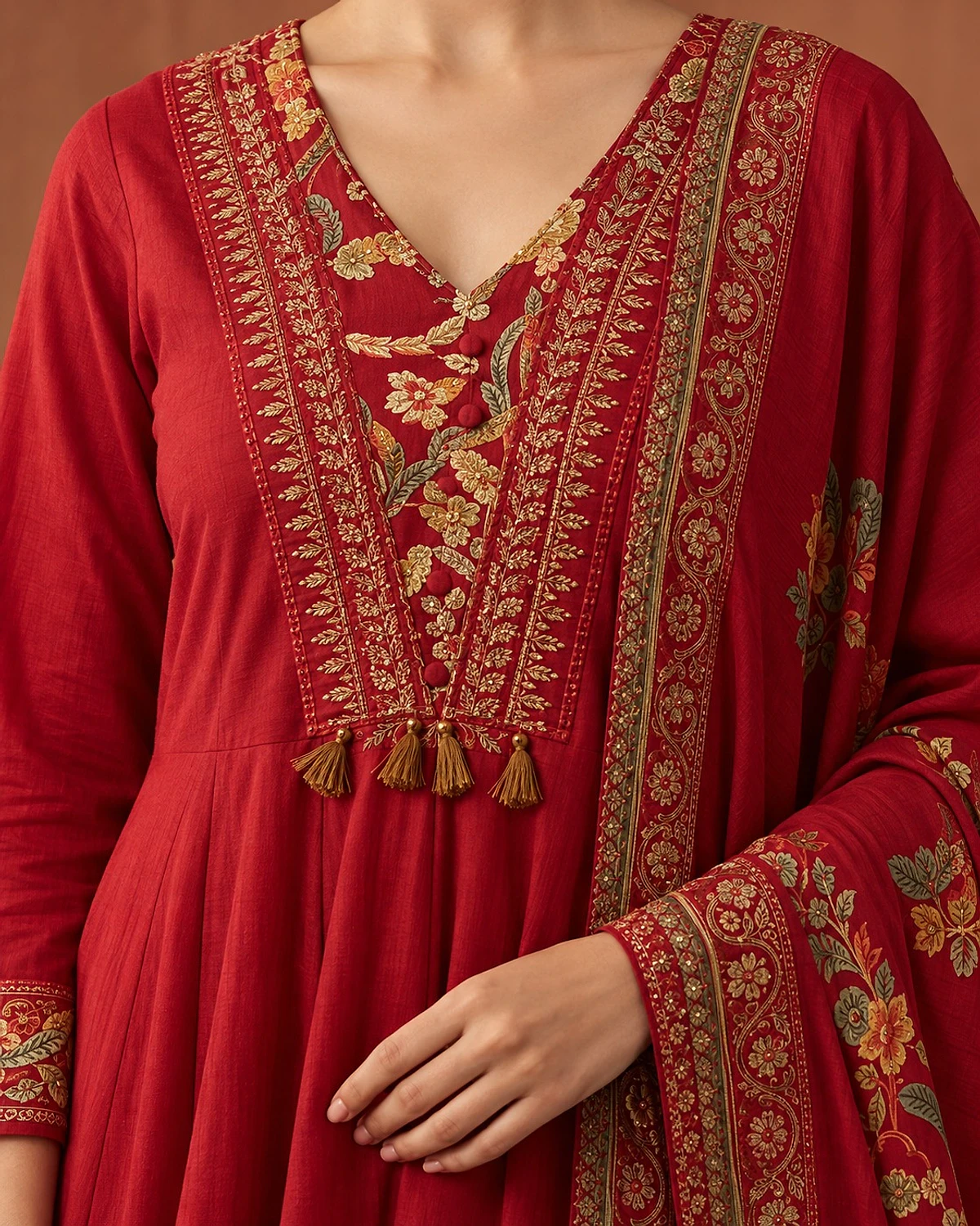 Close-up of the red kurta, showing floral printed borders and tassels