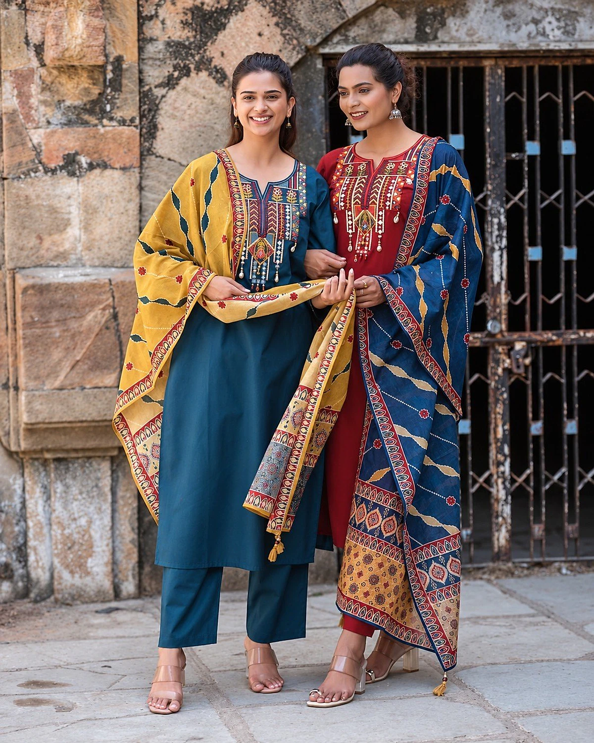 Two women in the same design: one in this peacock teal kurta set with dupatta, one in a red colourway