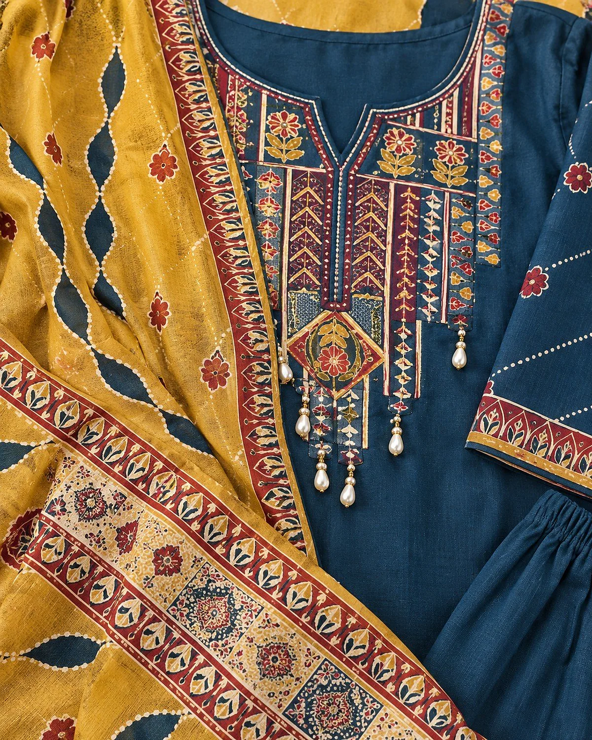 Close-up of the peacock teal kurta, showing a colourful yoke with bead drops