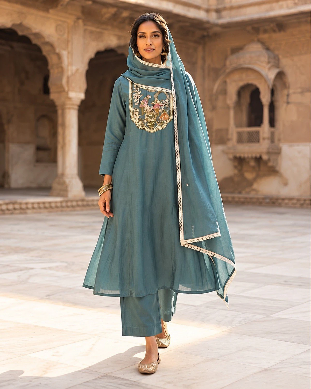 Woman wearing a turquoise kurta, trousers and dupatta
