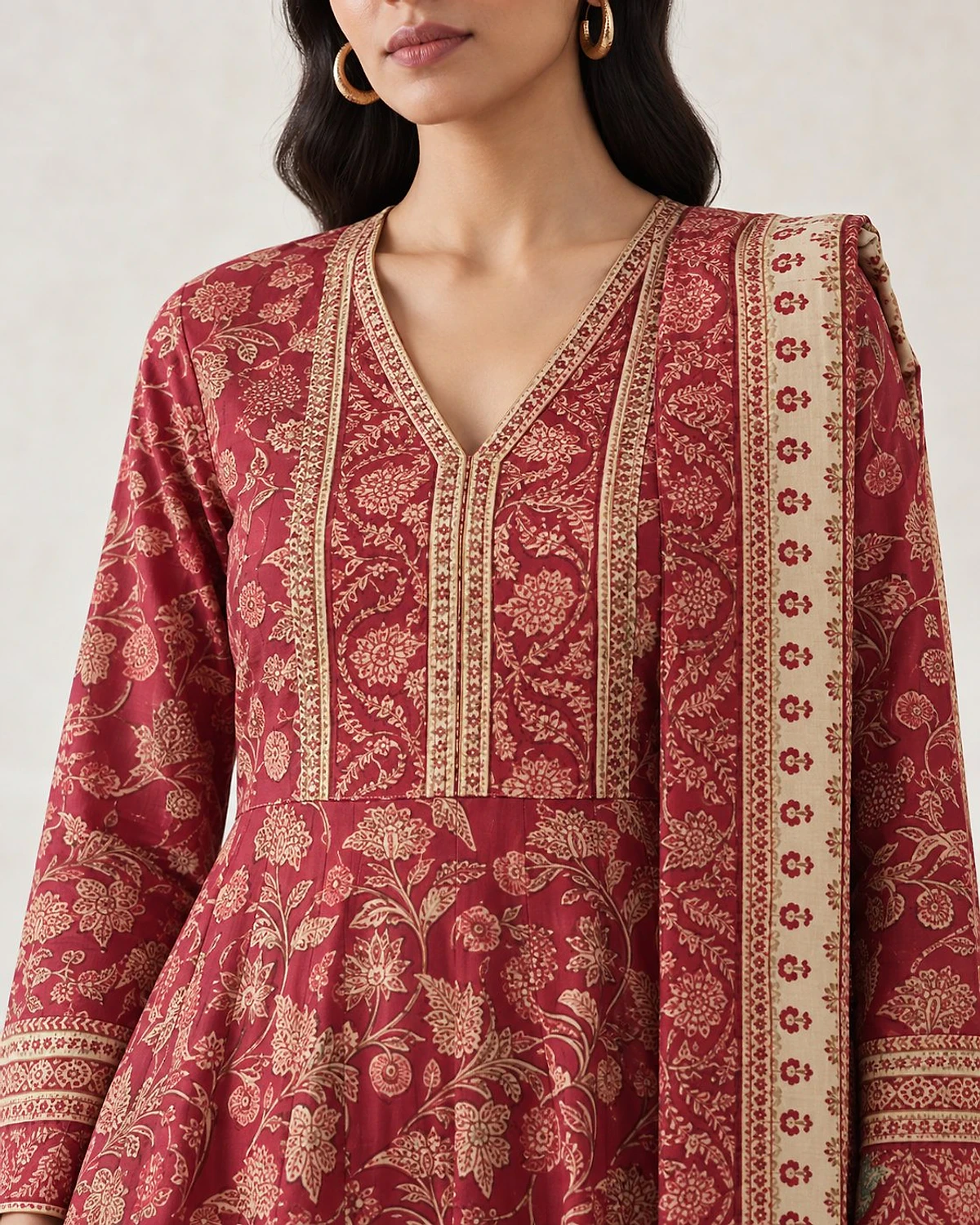 Close-up of the crimson kurta, showing a floral print and a printed yoke