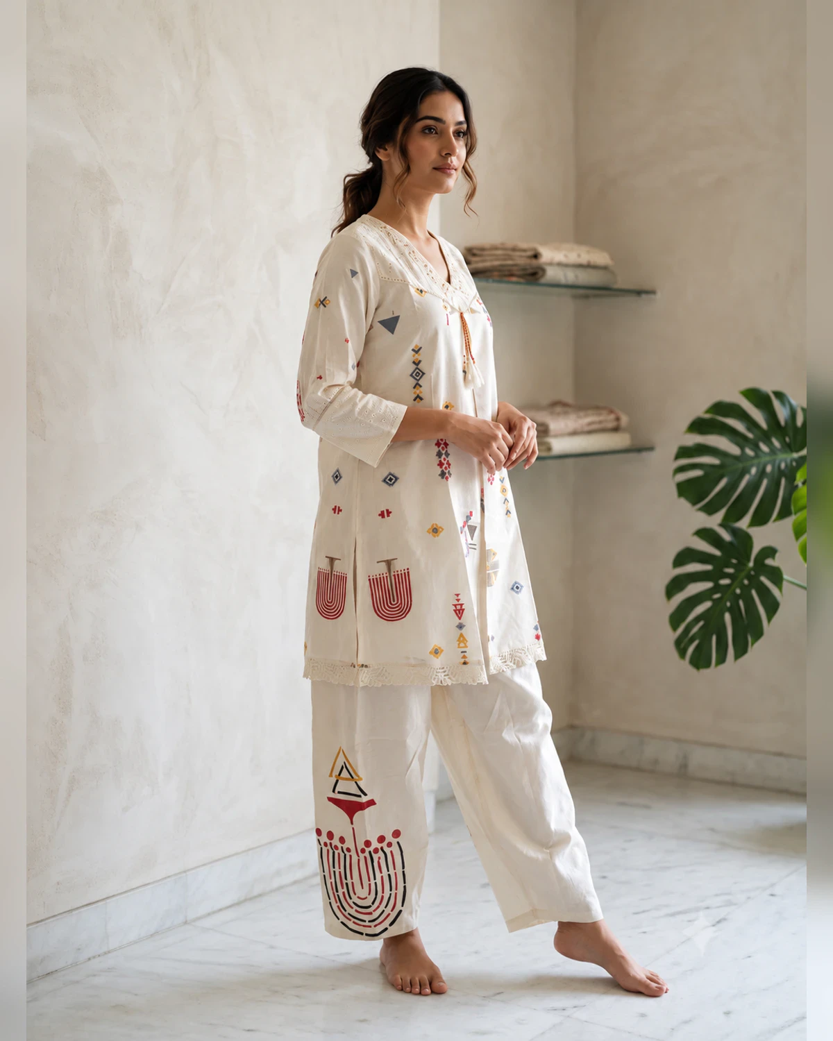 Woman wearing an ivory folk motif cotton tunic and trousers