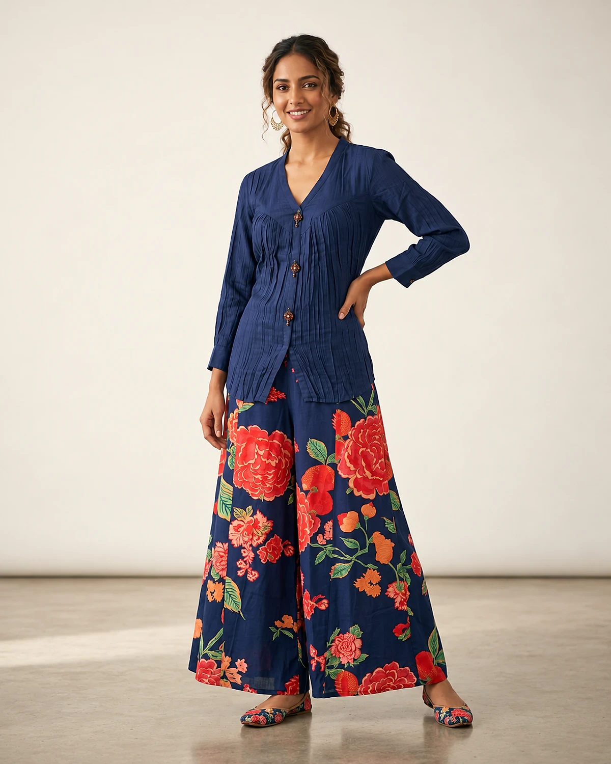 Woman wearing a navy crinkle top and red floral print palazzo