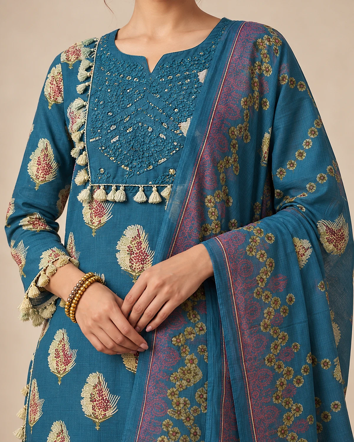 Close-up of the teal blue kurta's embellished yoke and tassels