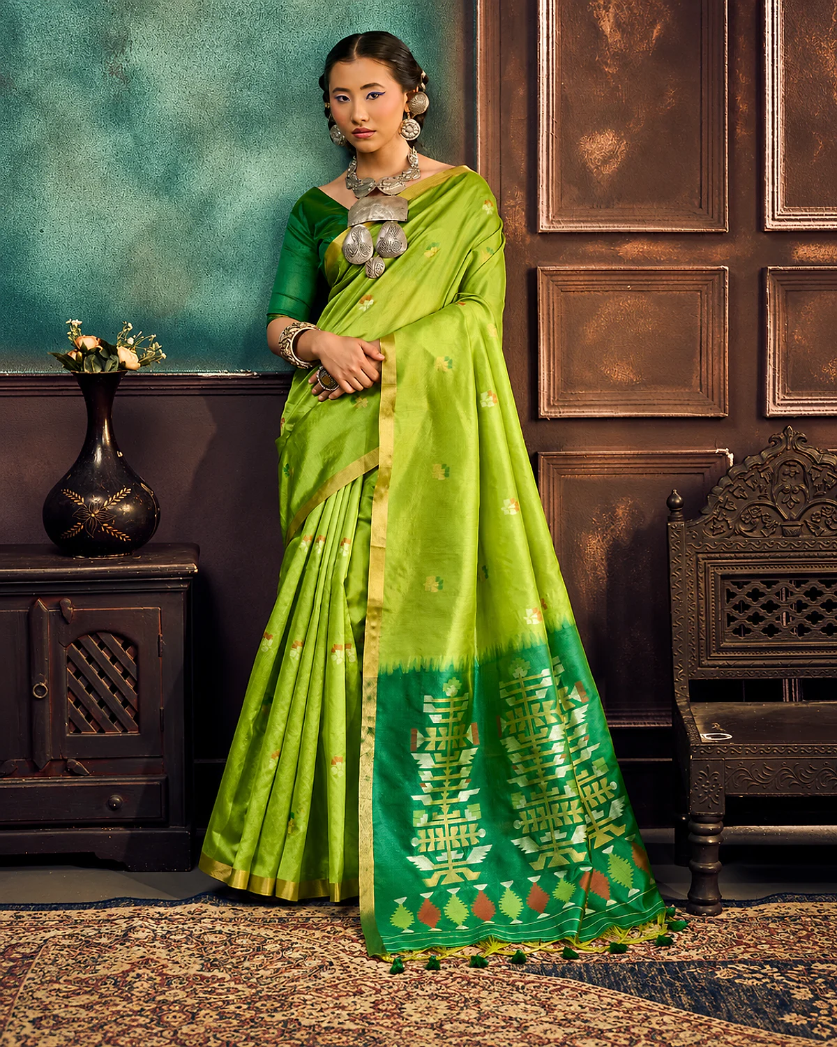 Woman wearing a lime green Kanoi Paithani tussar silk saree with a gold-tone border and a deep green geometric pallu with tassels