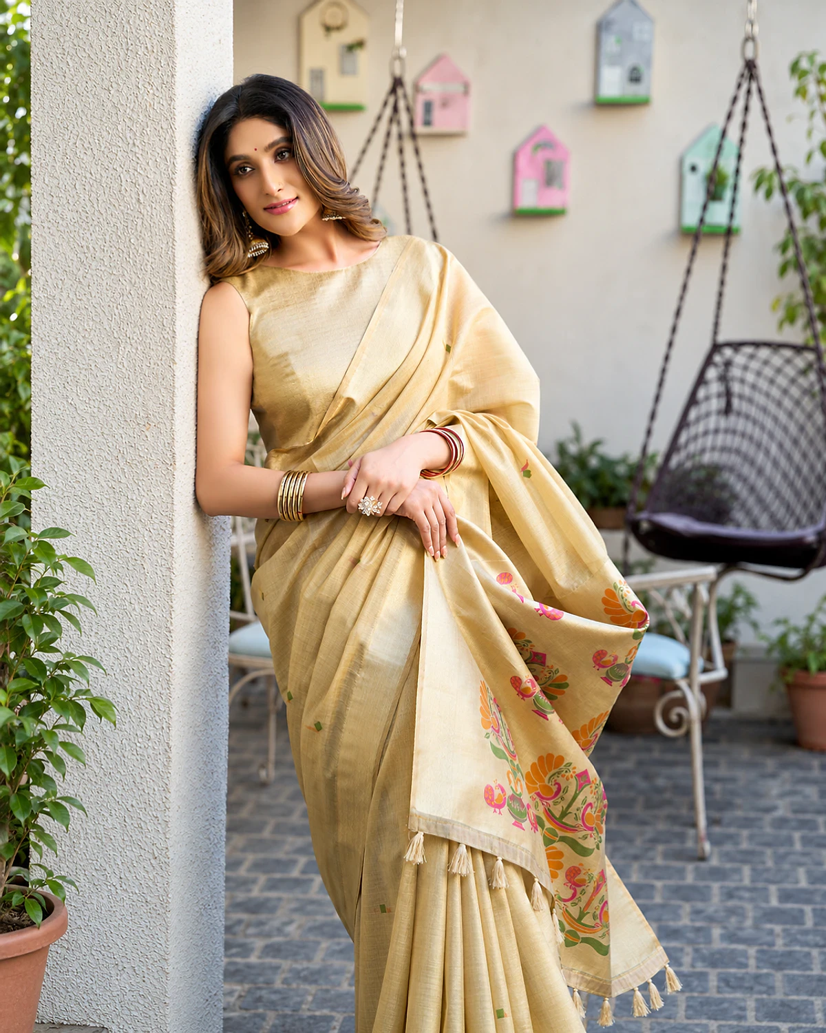 The champagne Surbhi saree's Paithani-style pallu and zari border up close, worn by a woman