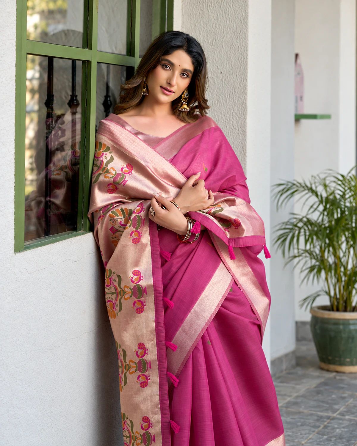 The pink Surbhi saree's Paithani-style pallu and zari border up close, worn by a woman
