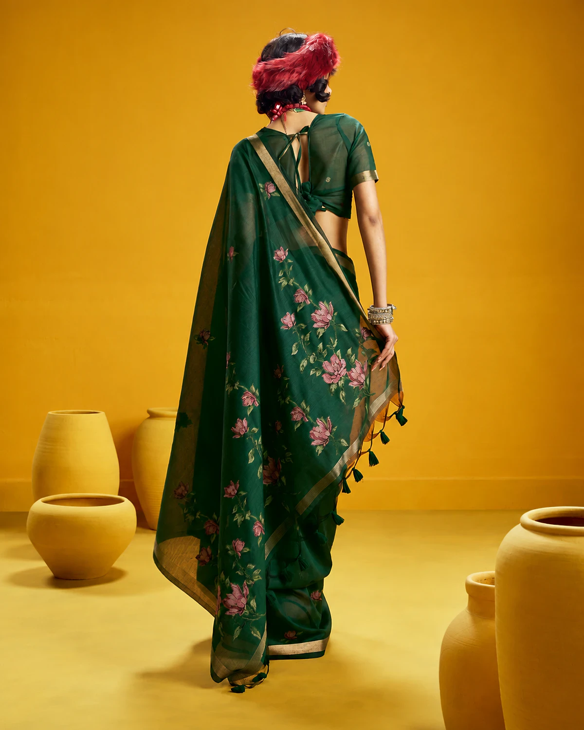 Back view of the bottle green Noorani munga cotton saree, its flower-covered pallu falling down the back
