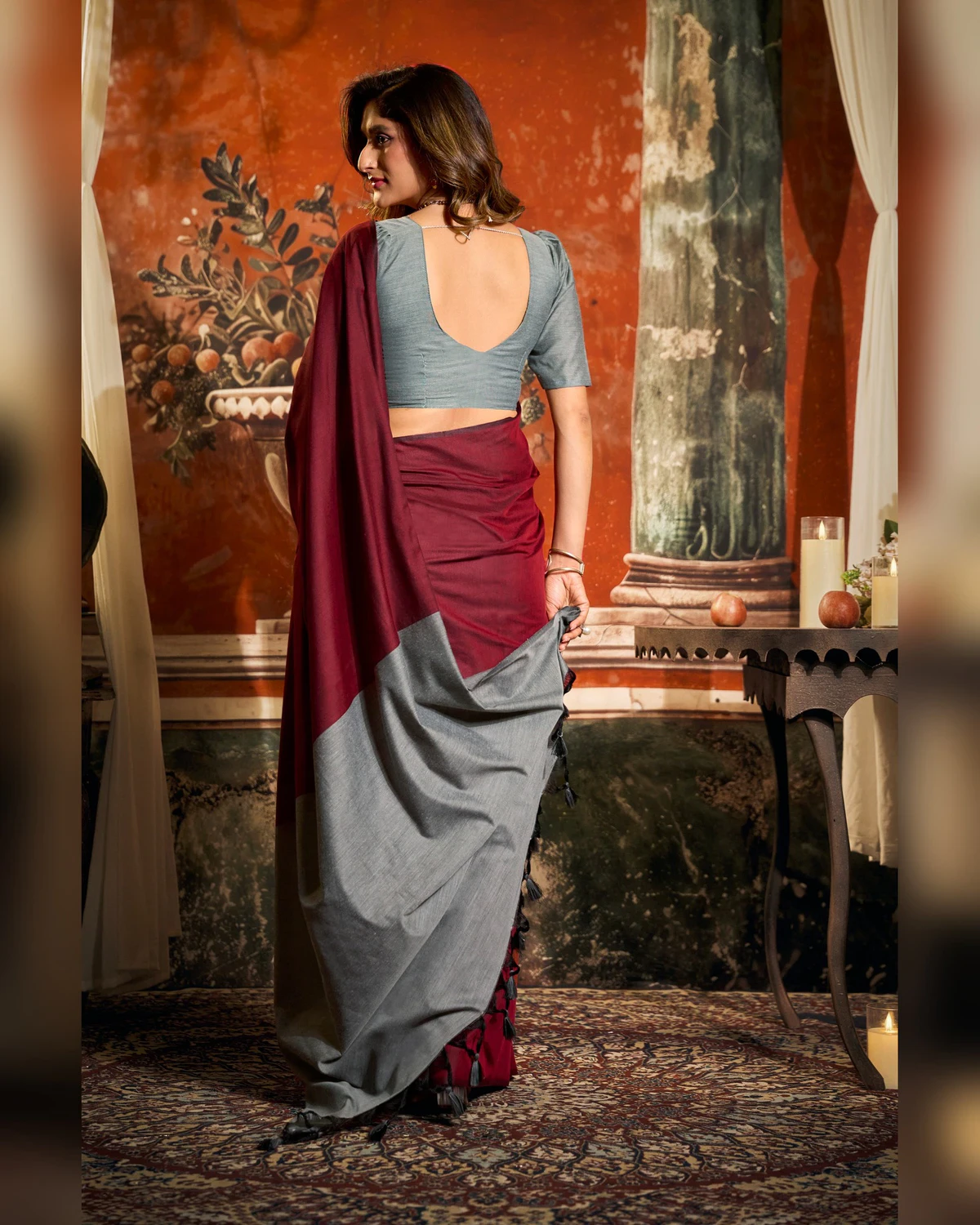 Back view of the maroon mal cotton saree, its grey pallu falling down the back
