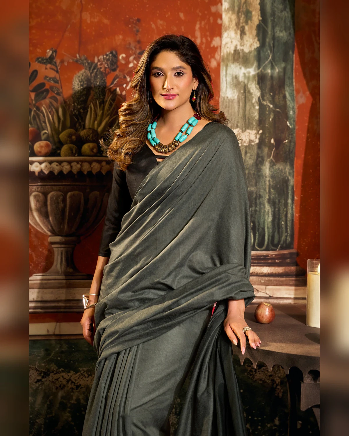 Woman in the charcoal grey mal cotton saree, its pallu over her arm, seen from the waist up