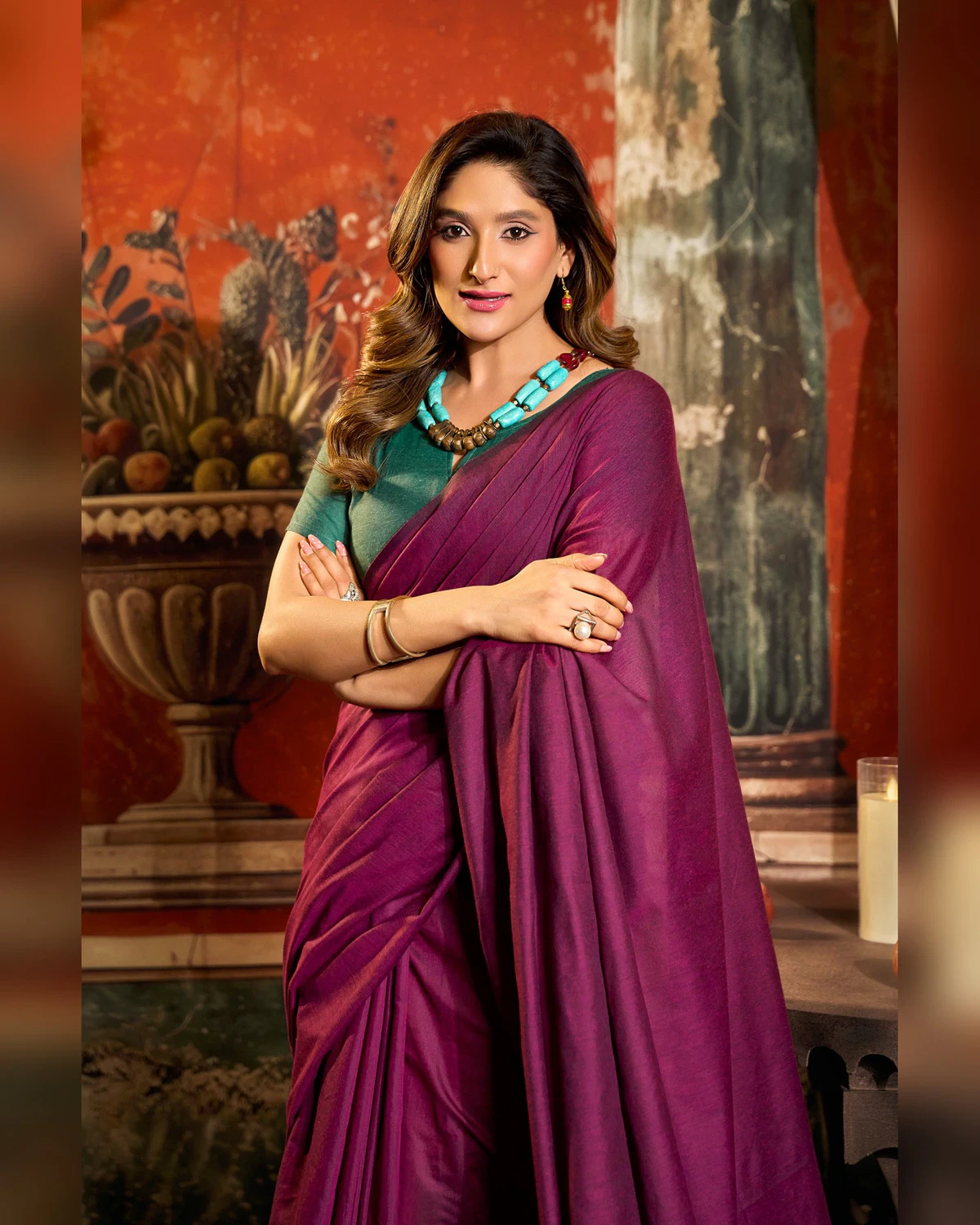 Woman in the magenta mal cotton saree with her arms folded, seen from the waist up