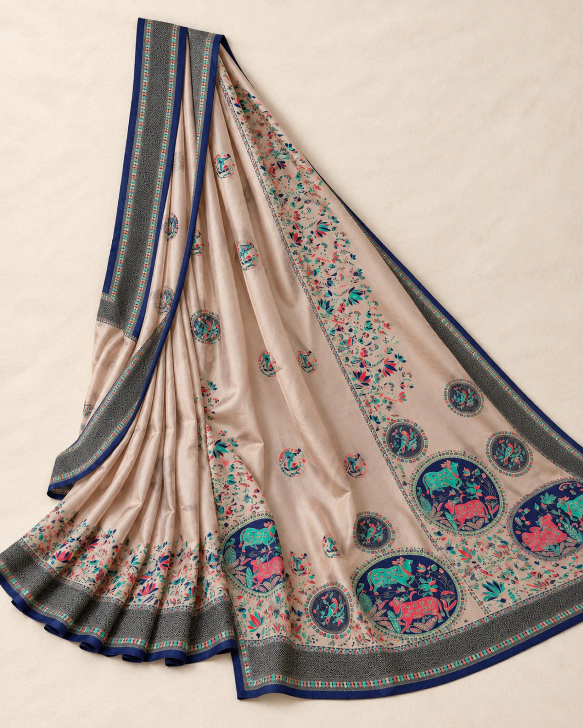 The beige sigma silk saree laid out flat, showing its navy blue border and medallion pallu