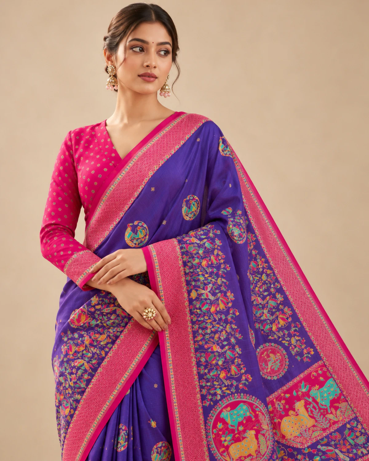 Close view of a woman in the purple sigma silk saree, showing its rani pink border and printed pallu