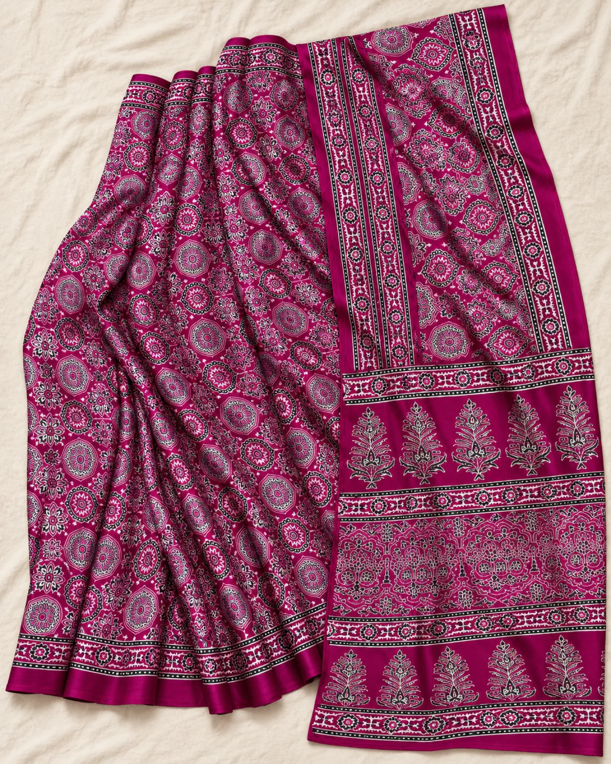 The plum modal satin saree laid out flat, showing its pink and white Ajrakh medallions and buta pallu