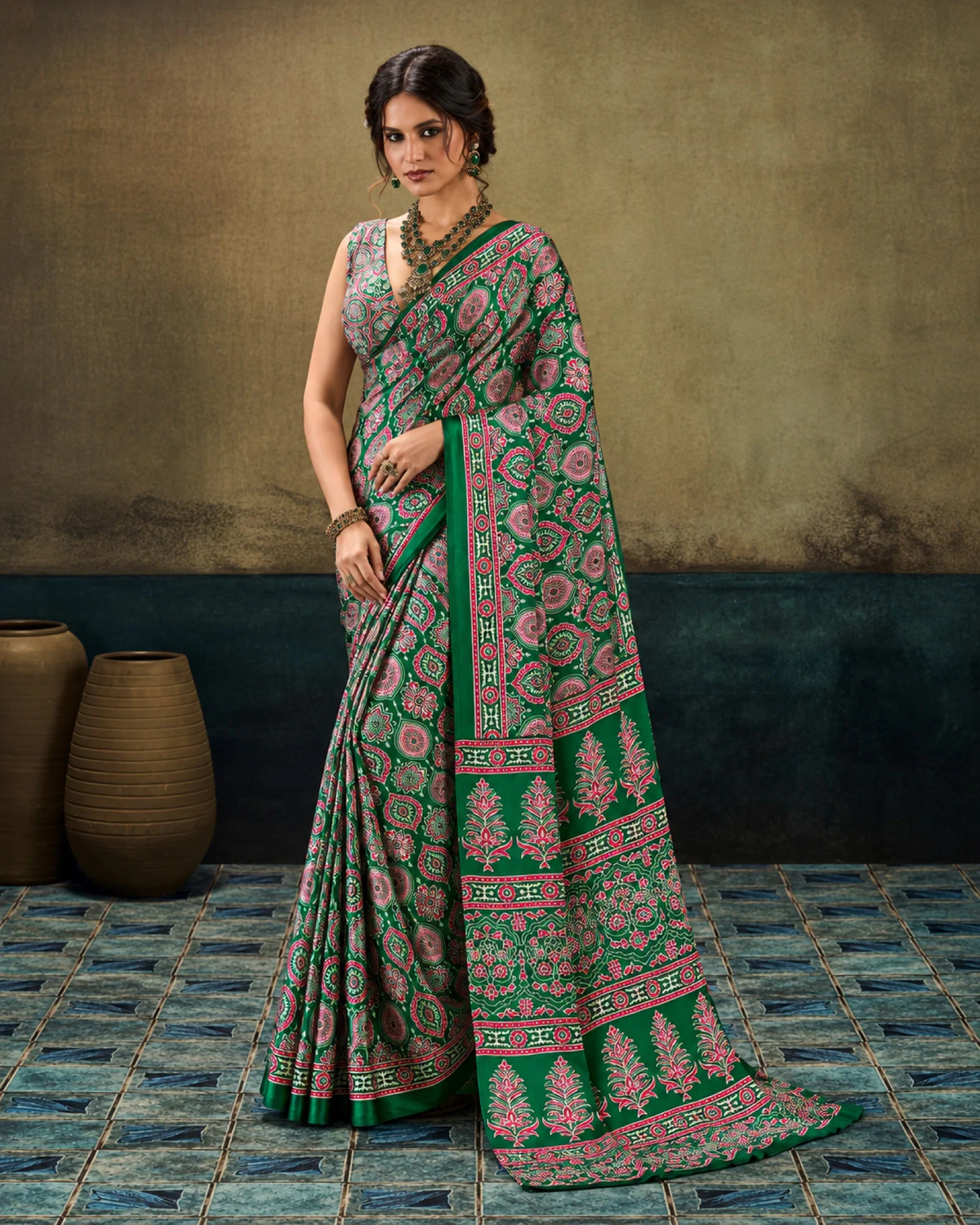 Woman in the emerald green modal satin saree with its long Ajrakh print pallu falling to the floor