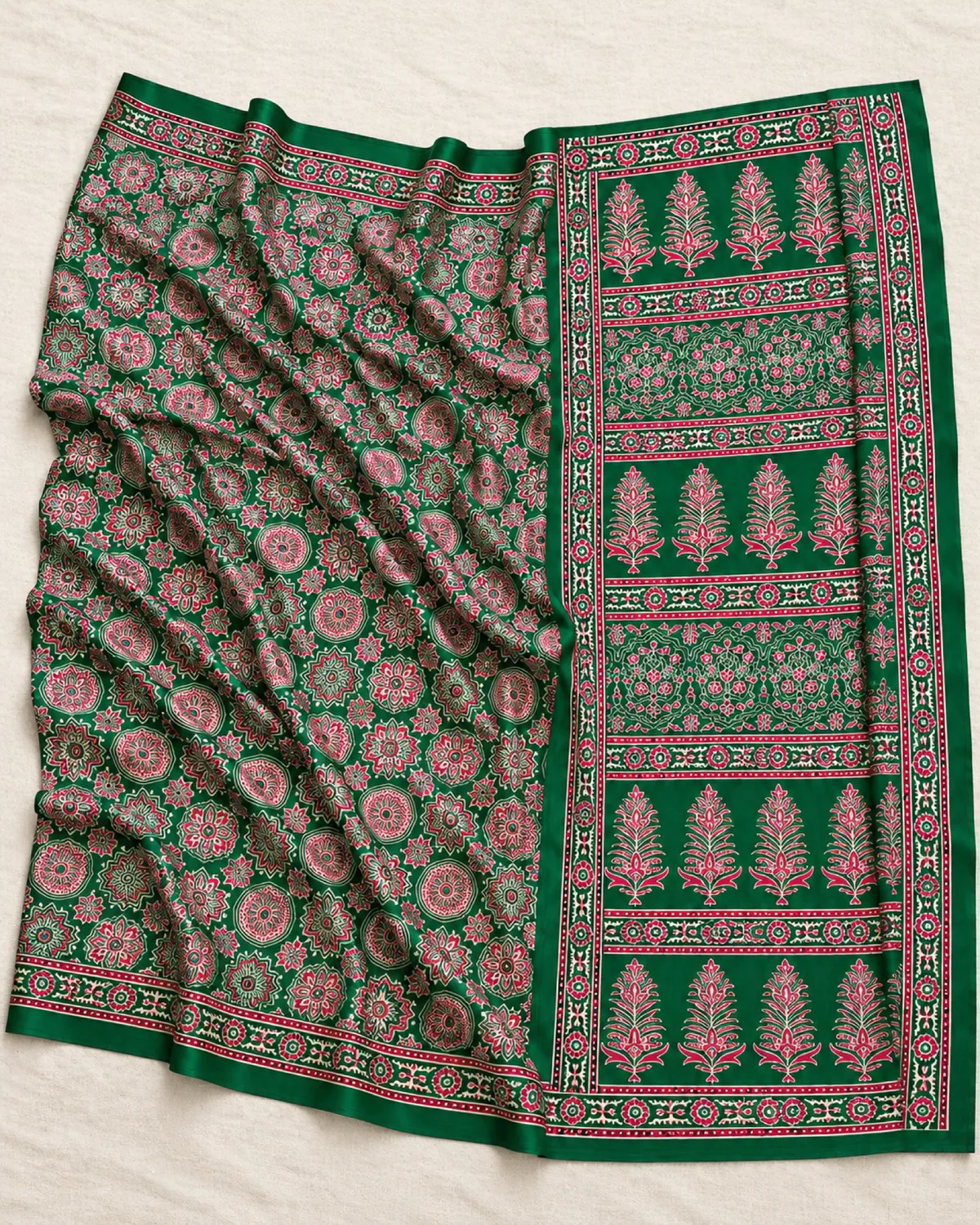 The emerald green modal satin saree laid out flat, showing its pink and grey Ajrakh medallions and buta pallu