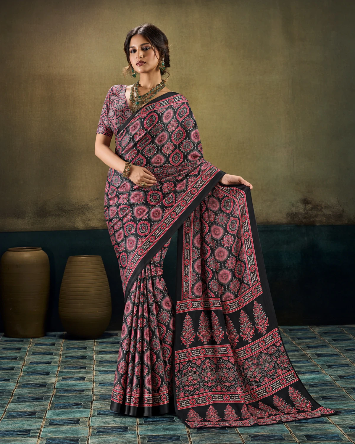 Woman in the black modal satin saree with its long Ajrakh print pallu falling to the floor