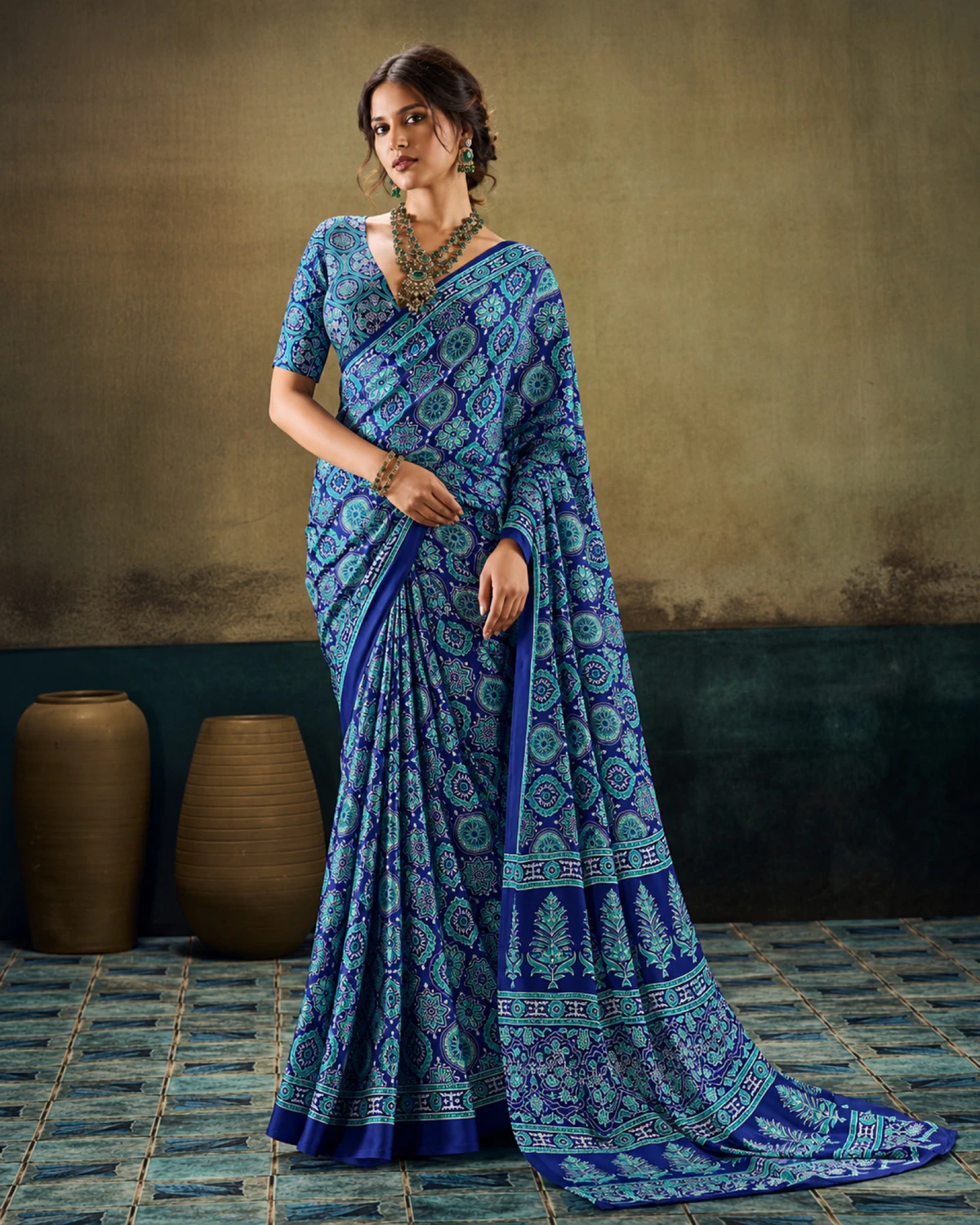 Woman in the blue modal satin saree with its long Ajrakh print pallu falling to the floor