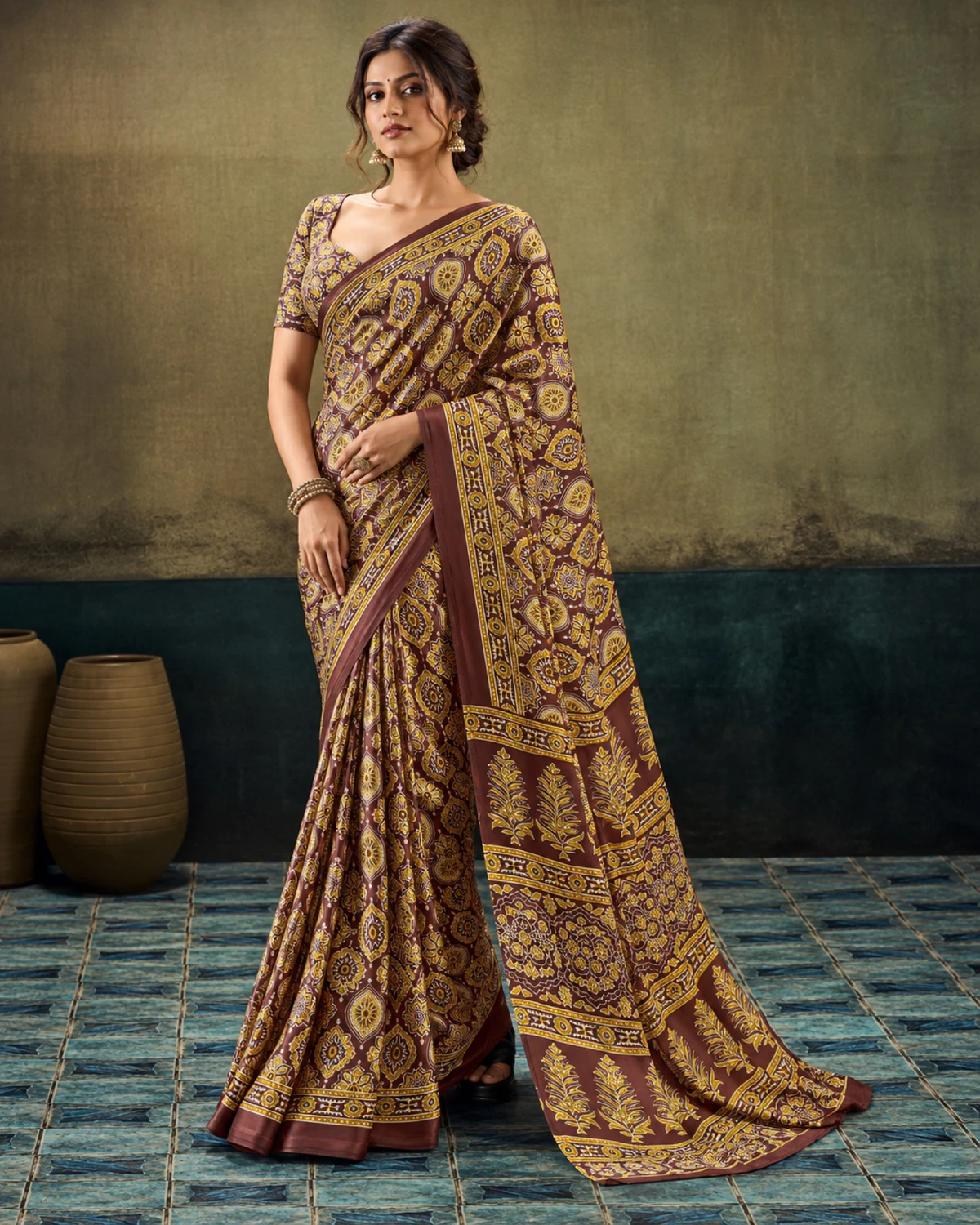 Woman in the brown modal satin saree with its long Ajrakh print pallu falling to the floor
