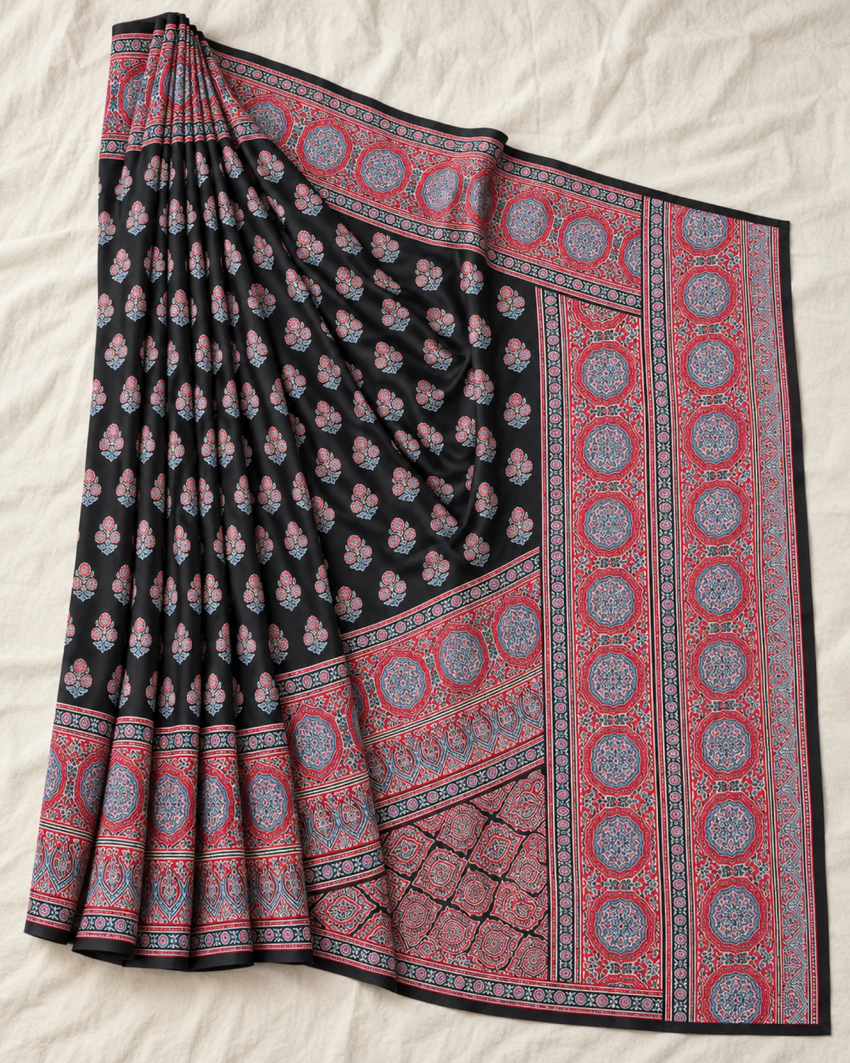 The black and red modal satin saree laid out flat, showing its small butis and wide red medallion border