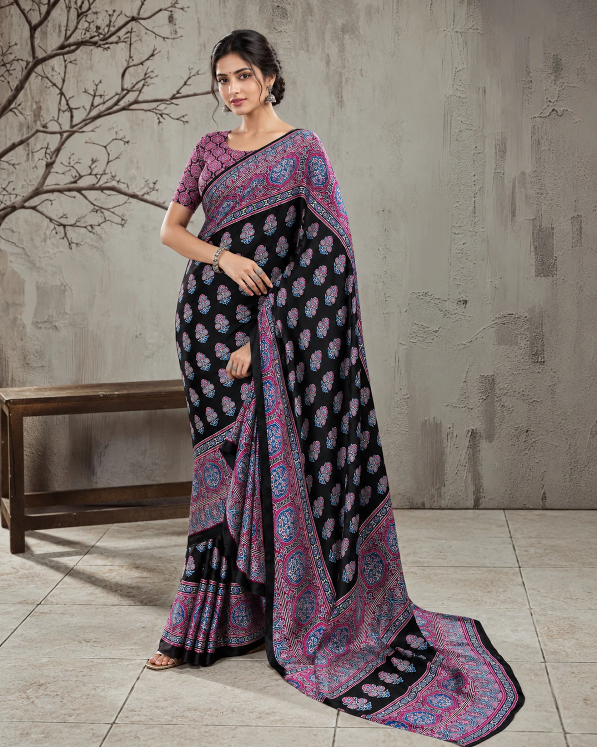 Woman in the black and purple modal satin saree, its long pallu with purple medallions falling to the floor
