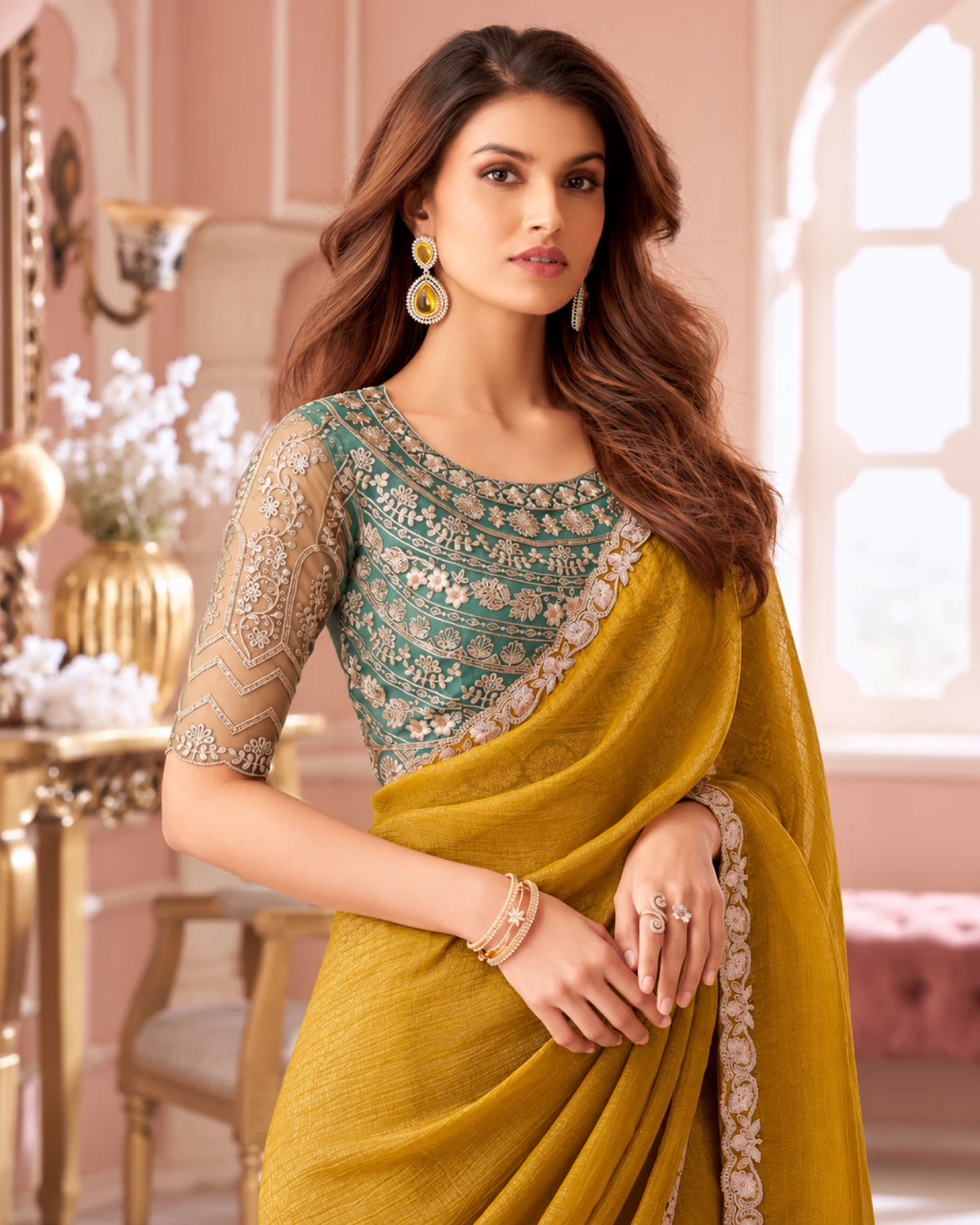 Close-up of the mustard yellow georgette saree's ivory border with a teal green embroidered blouse