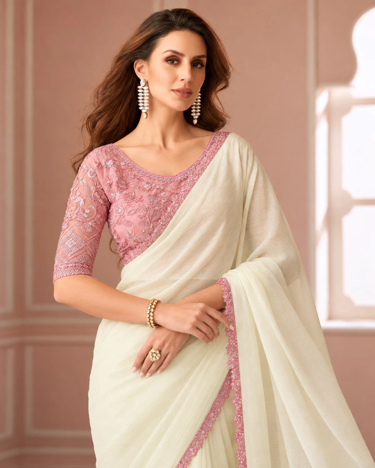 Close-up of the ivory georgette saree's pink border with a pink embroidered blouse