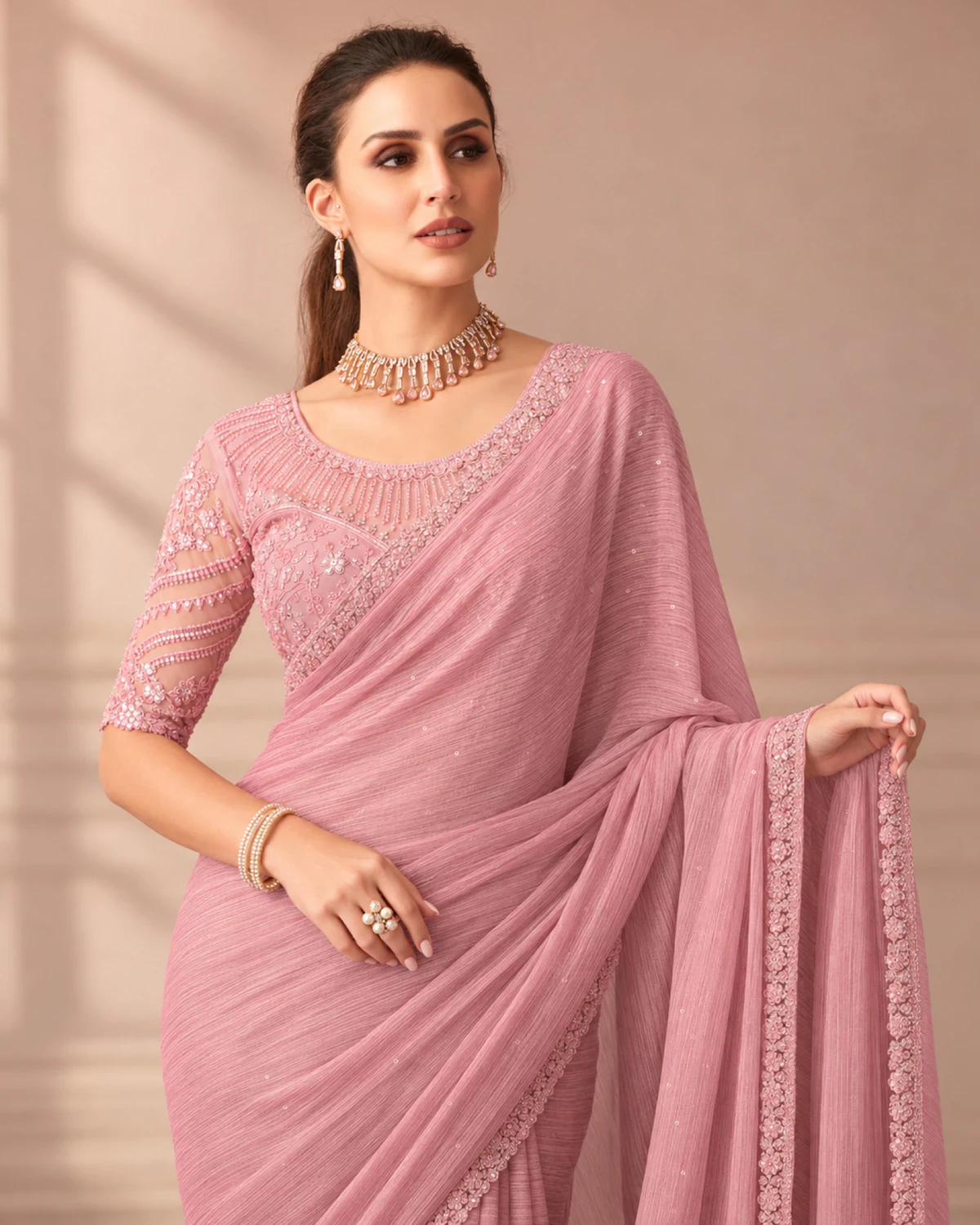 Close-up of the blush pink georgette saree's border with a blush pink embroidered blouse
