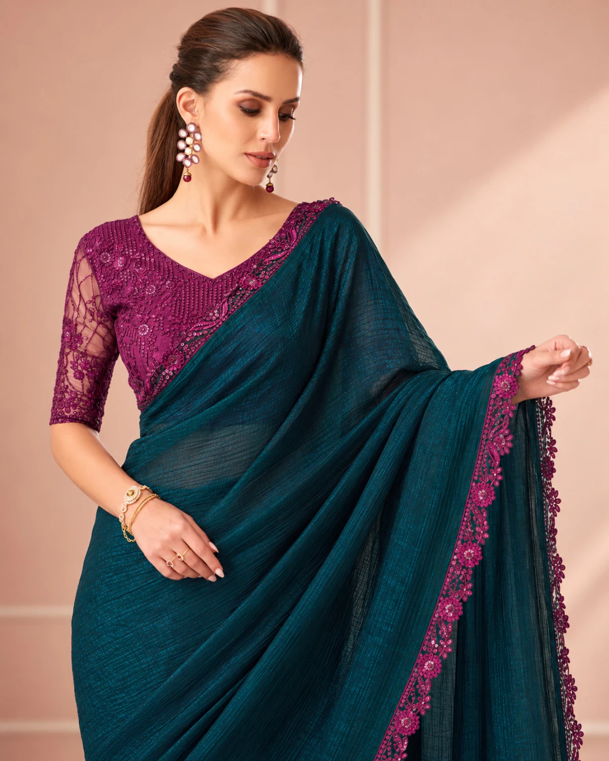 Close-up of the deep teal peacock rainbow saree's magenta border with a magenta embroidered blouse