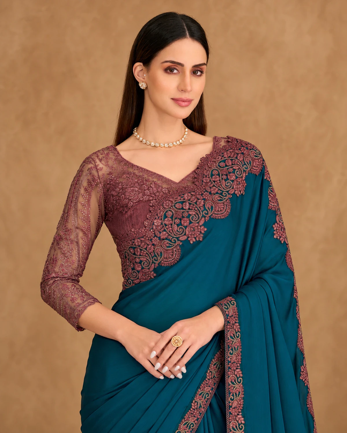 Close-up of the teal satin chiffon saree's embroidered shoulder and the wine embroidered blouse