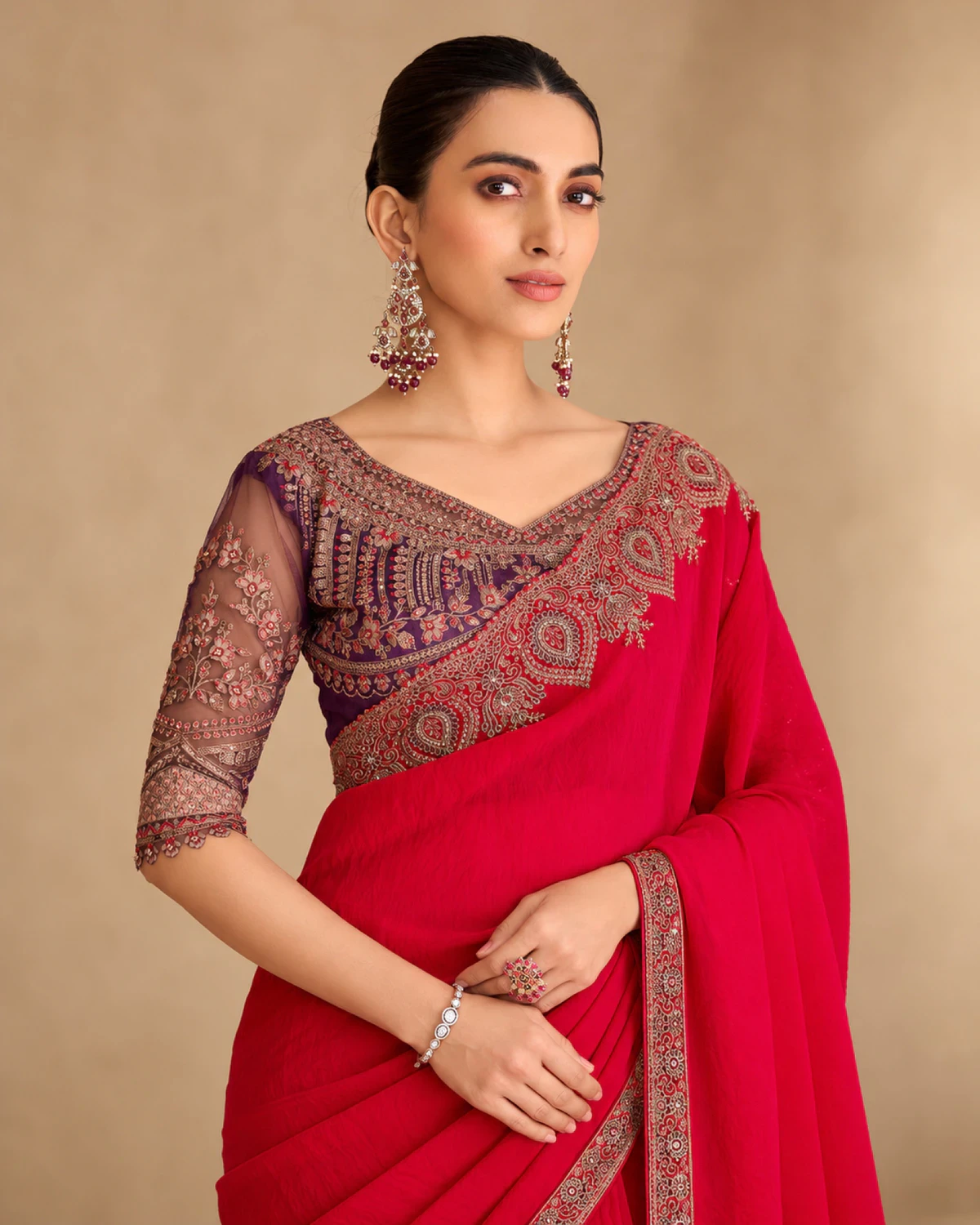 Close-up of the red satin georgette saree's embroidered shoulder and the deep purple embroidered blouse