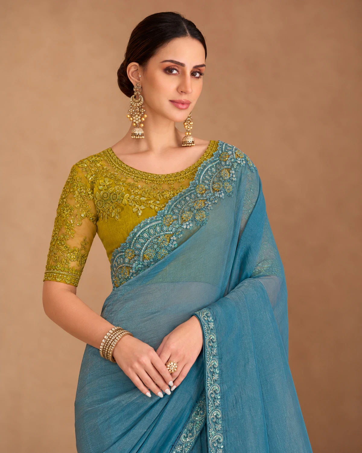 Close-up of the powder blue tissue georgette saree's embroidered shoulder and the olive green embroidered blouse
