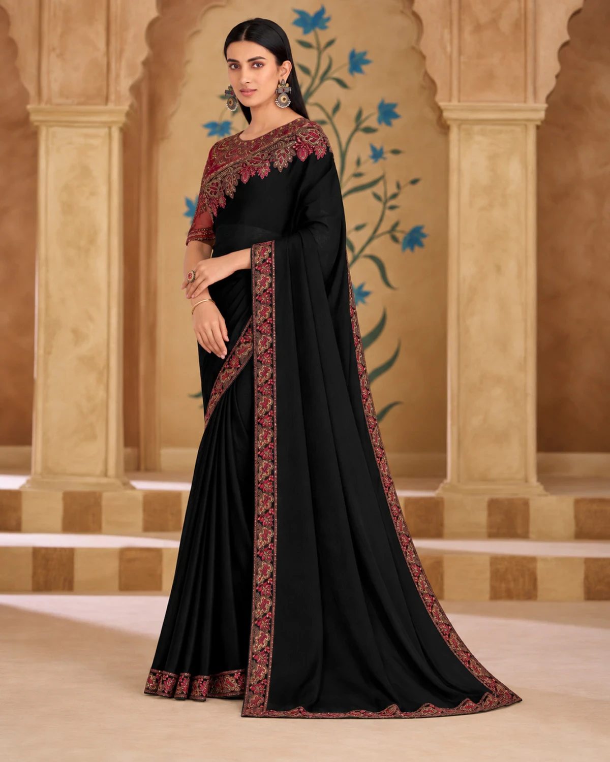 Full-length view of the black georgette silk saree with its red embroidered border, under carved arches
