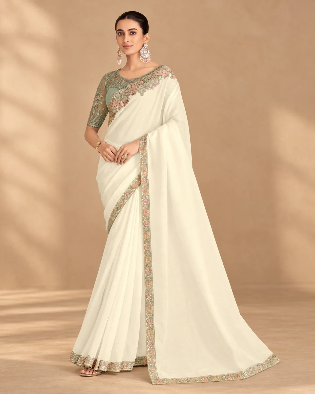 Full-length view of the ivory satin saree with its sage green embroidered border