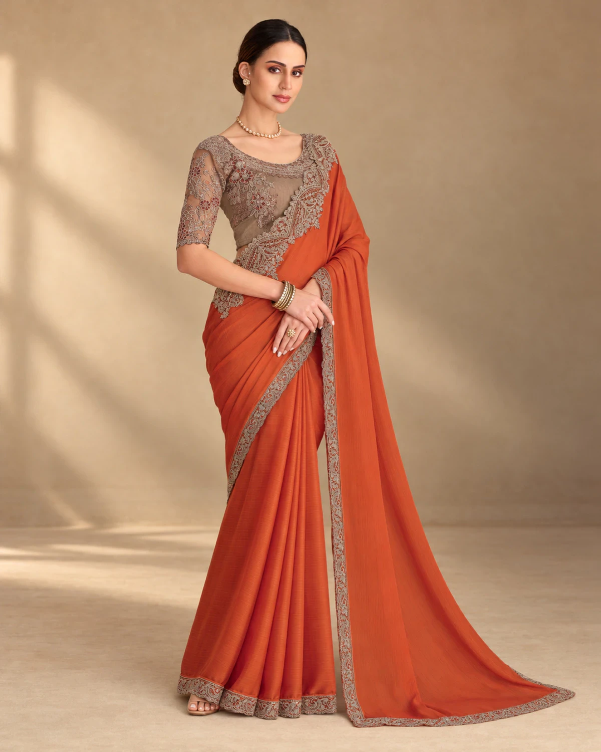 Full-length view of the rust satin chiffon saree with its embroidered border
